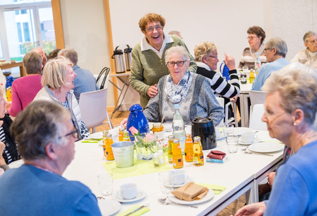Menschen sitzen gemeinsam am Tisch und tauschen sich aus