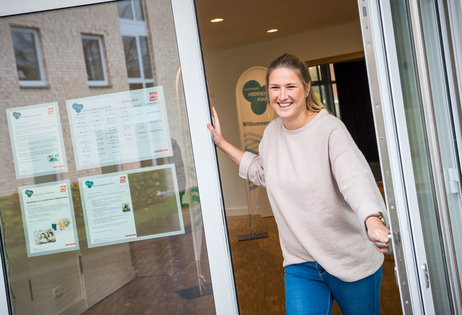 Die Quartiersmanagerin Vivien Behrens öffnet freundlich lächelnd die Tür des Quartiershauses Middenmang.