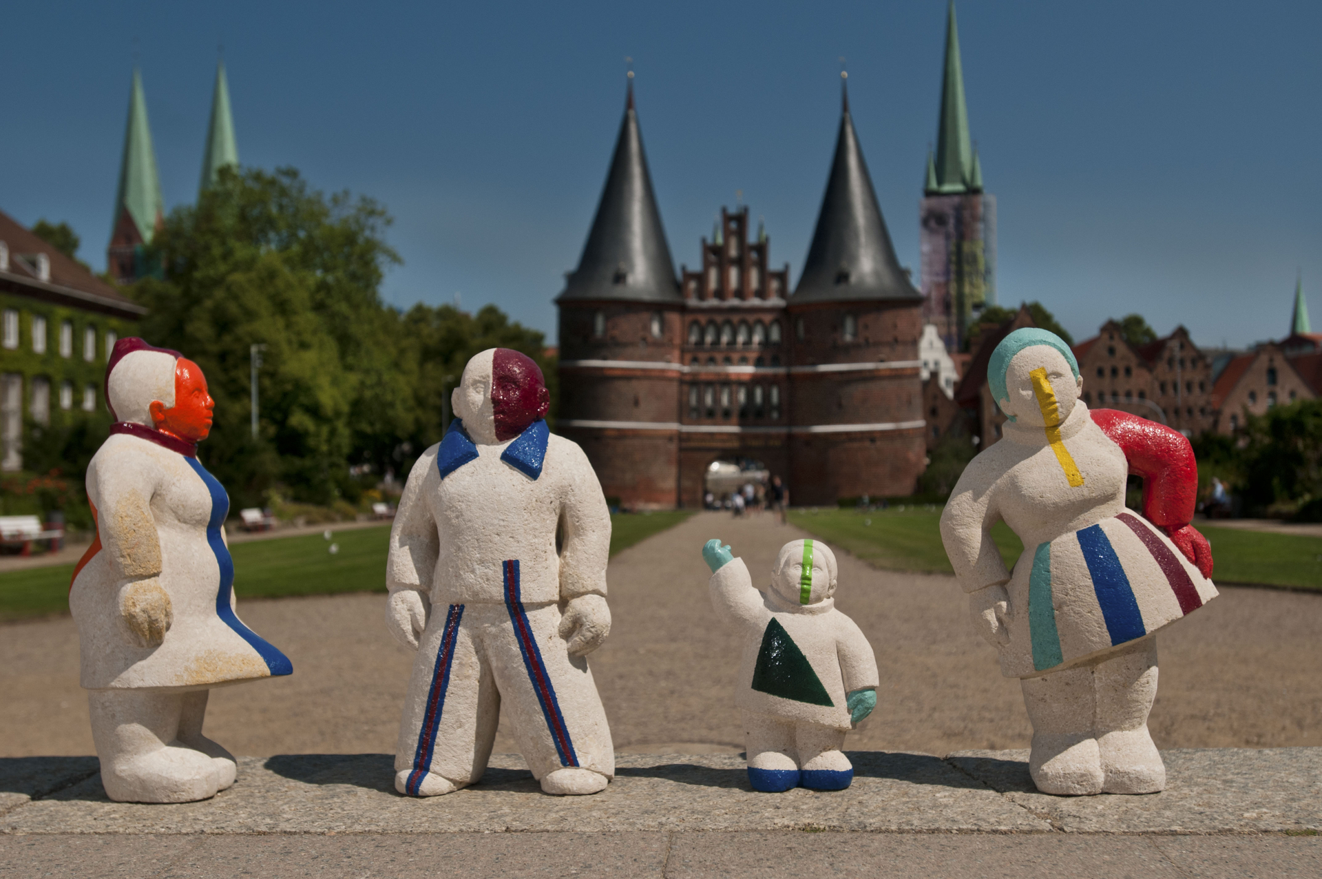 Die vier Figuren des Kunstwerkes "Moislinger Gesellschaft" von Bettina Thierig vor dem Holstentor. Die Figuren symbilisieren die Vielfalt der Mieterinnen und Mieter der TRAVE.